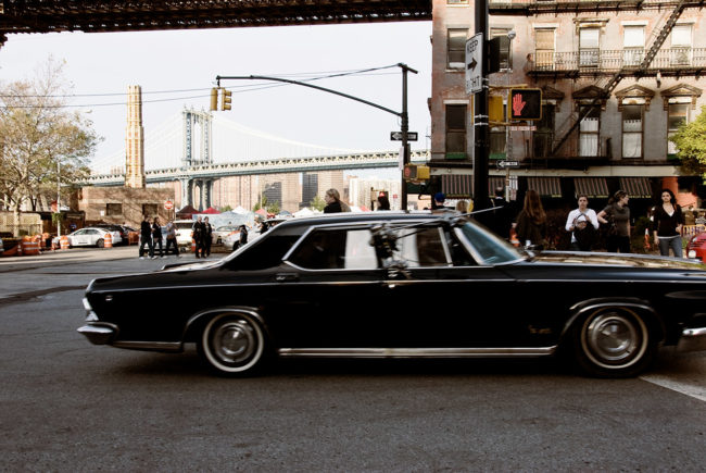 An old car is crossing the streets of Brooklyn.