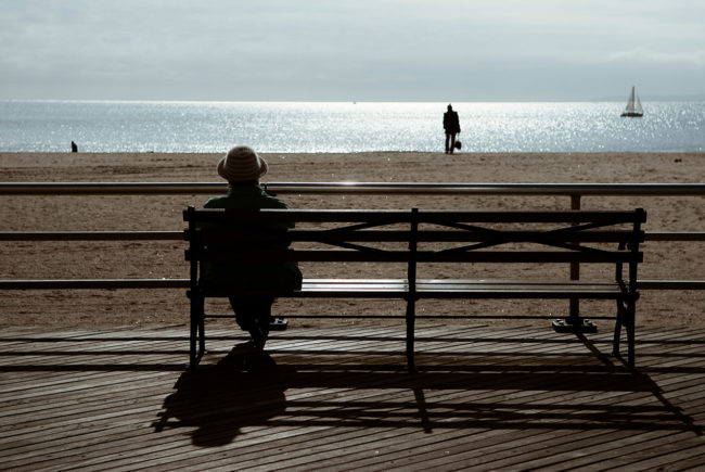 The woman on a Coney island’s boardwalk bench.