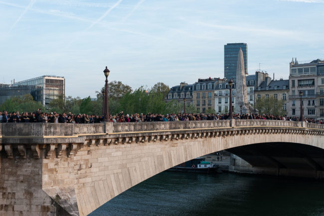 The crowd watches Notre-Dame burn from the Sully bridge. La foule regarde Notre-Dame brûler depuis le pont de Sully.