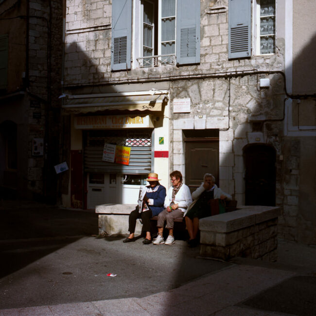 3 elderly people are sitting on a bench in Sisteron.Trois vieilles dames sont assises sur un banc de Sisteron.